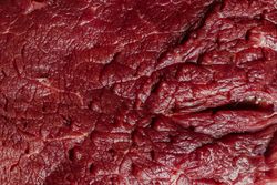 Detailed close-up of raw beef meat showcasing its rich texture and marbling.