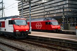 Two modern red trains at Zurich train station, early evening setting.